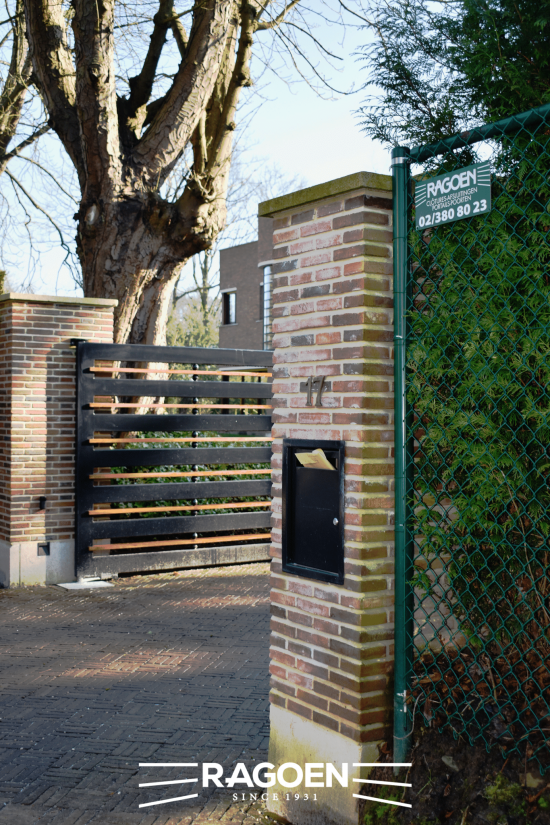 une plaque Ragoen sur un grillage avec un portail en bois